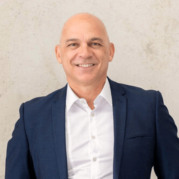 A person in a suit smilingAI-generated content may be incorrect.